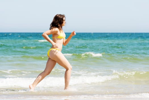 happy woman in bikini running on the beach