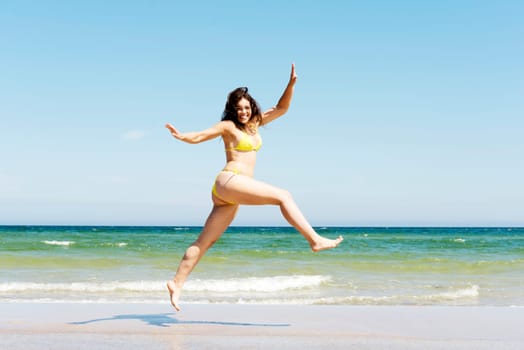 happy free girl jumping on the beach