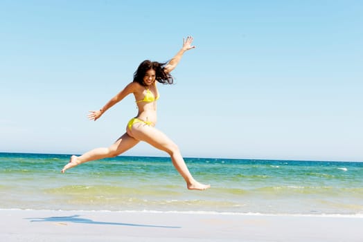 happy free girl jumping on the beach