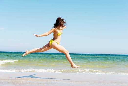 happy free girl jumping on the beach