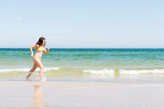 happy woman in bikini running on the beach