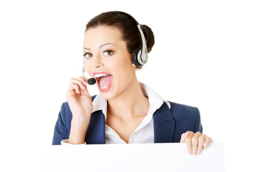 pretty young call center worker wearing a headset and holding blank sign board