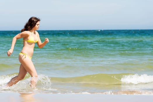 happy woman in bikini running on the beach