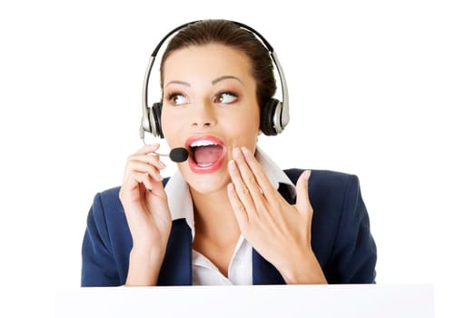 pretty young call center worker wearing a headset and holding blank sign board