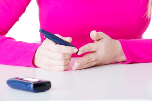 diabetes patient measuring glucose level blood test using ultra mini glucometer and small drop of blood from finger isolated on a white background