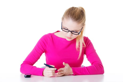 diabetes patient measuring glucose level blood test using ultra mini glucometer and small drop of blood from finger isolated on a white background
