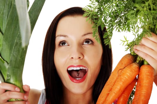 happy,excited woman in apron holding fresh leek and carrot