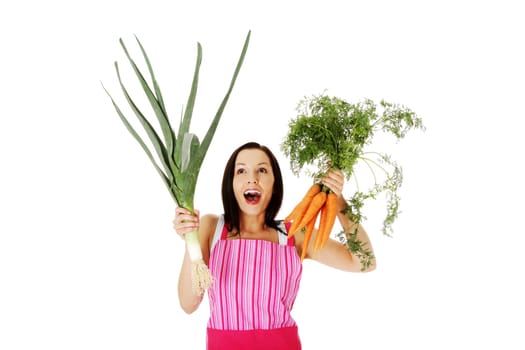 happy,excited woman in apron holding fresh leek and carrot