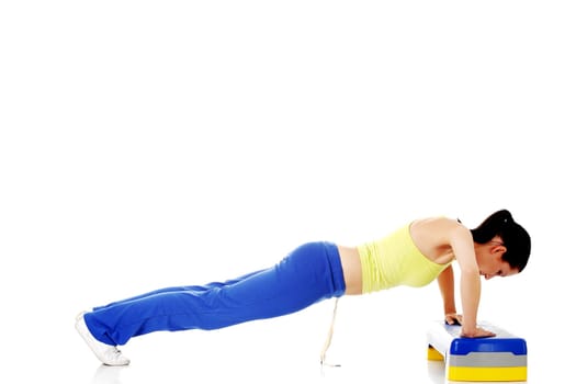 fitness girl is working out with stepper,isolated on white background