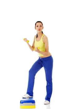 fitness girl is working out with stepper,isolated on white background