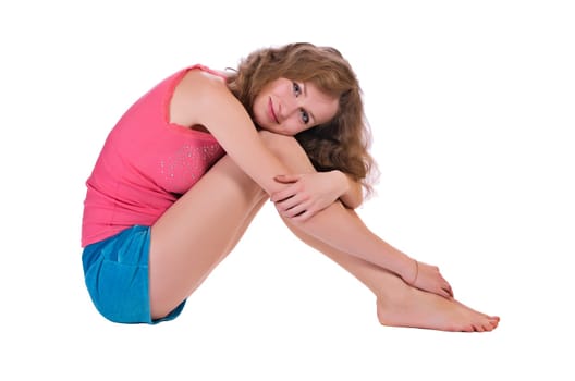 Girl sitting in shorts and a t-shirt, isolated
