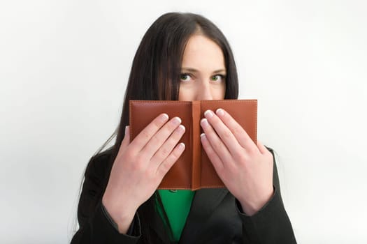 Girl hiding behind the book on a white background