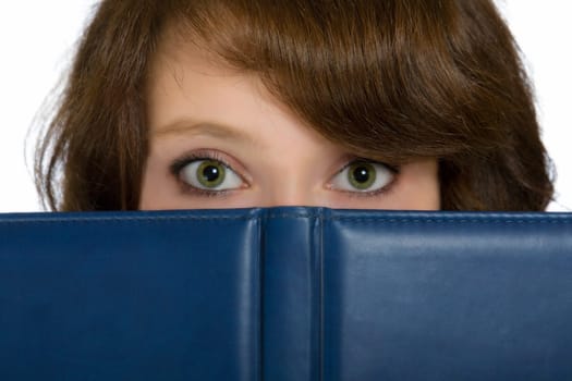 beautiful girl hiding behind a blue open book