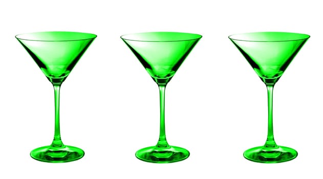 Three green empty martini glasses in a row isolated