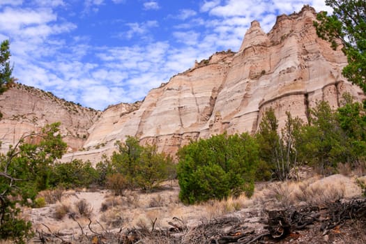 Huge stone formation with green bushes and junipers