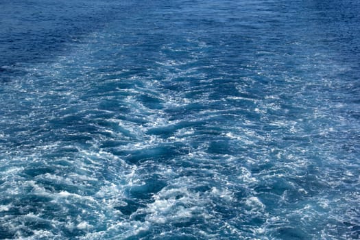 Background of waves in the ocean behind a ship