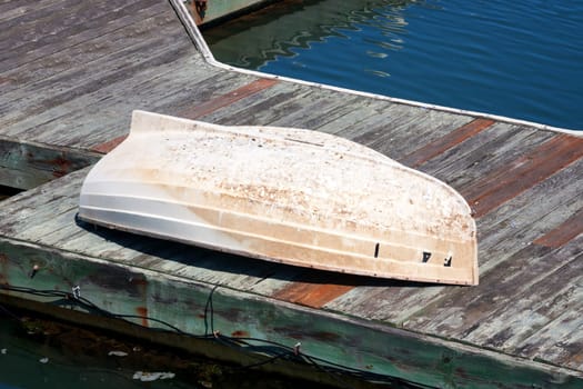 An old boat abandoned and turned over on a pier