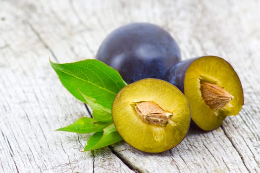 fresh plums on old wooden background