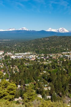 A vertical shot of the city of Bend with the Three Sisters of the Cascade Range