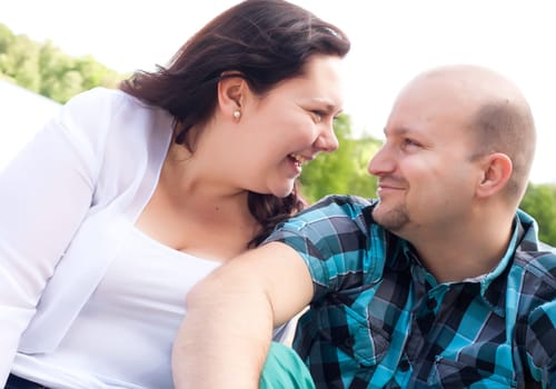 Happy young couple is having fun on a windy park beach