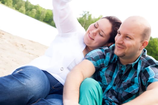 Happy young couple is having fun on a windy park beach