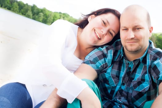 Happy young couple is having fun on a windy park beach