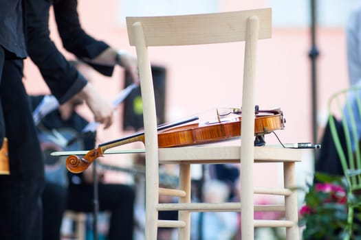 Violin on a wooden chair before the concert