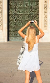 Woman photographing the portal of the Milan cathedral