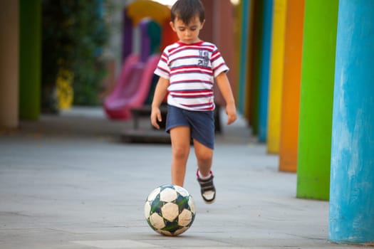 Cute boy running with a soccer ball