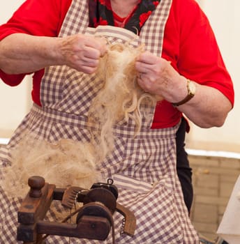 Photo of a elderly woman that spinning wool
