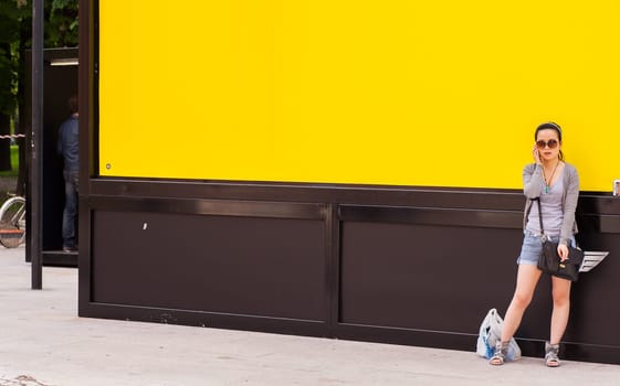 Teenager oriental girl on yellow wall. Fuori salone, Triennale - Mini car exhibition-