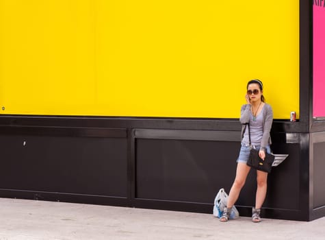 Teenager oriental girl on yellow wall. Fuori salone, Triennale - Mini car exhibition- .http