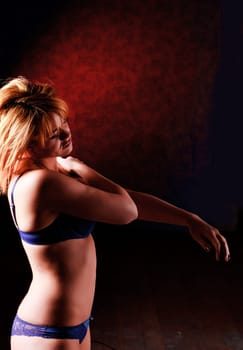 Sensual blonde girl in underwear on dark background