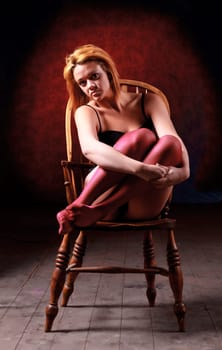 Sensual blonde girl in underwear on wooden chair