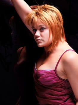 Sensual blonde girl in underwear lie and reflecting on dark background