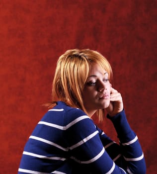 Girl sitting on the stool on red background