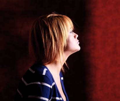 Girl sitting on the stool on red background