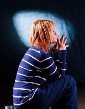 Girl sitting on the stool on dark background