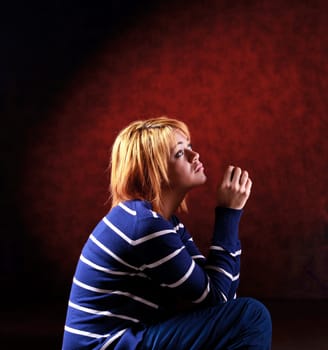 Girl sitting on the stool on red background