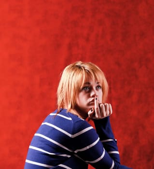 Girl sitting on the stool on red background