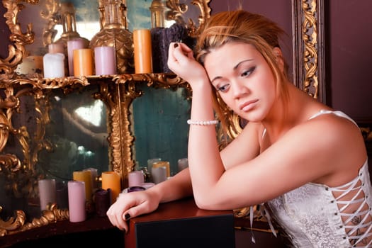 Sensual blonde girl in underwear next to a old mirror