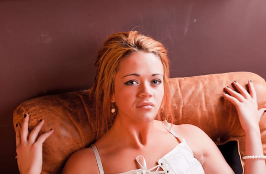 Sensual blonde girl in underwear on armchair
