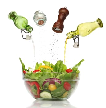 Pouring condiments on a colorful salad. isolated