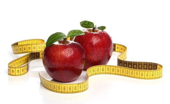 Red apples and a measuring tape over white