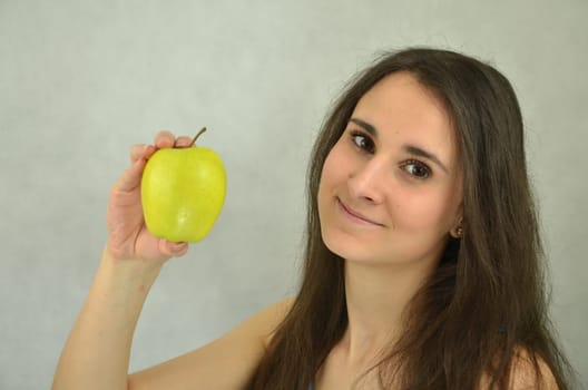 Beautiful young girl is holding an apple