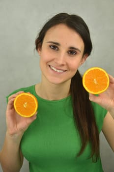 Beautiful young girl is holding an orange