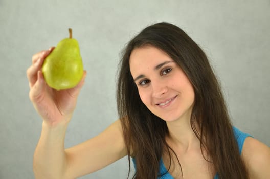 Beautiful young girl is holding a pear