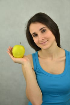 Beautiful young girl is holding an apple