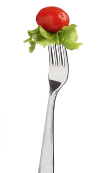 Fork with letucce and tomato over white