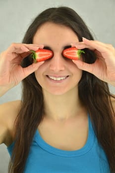 Beautiful young girl is holding strawberries